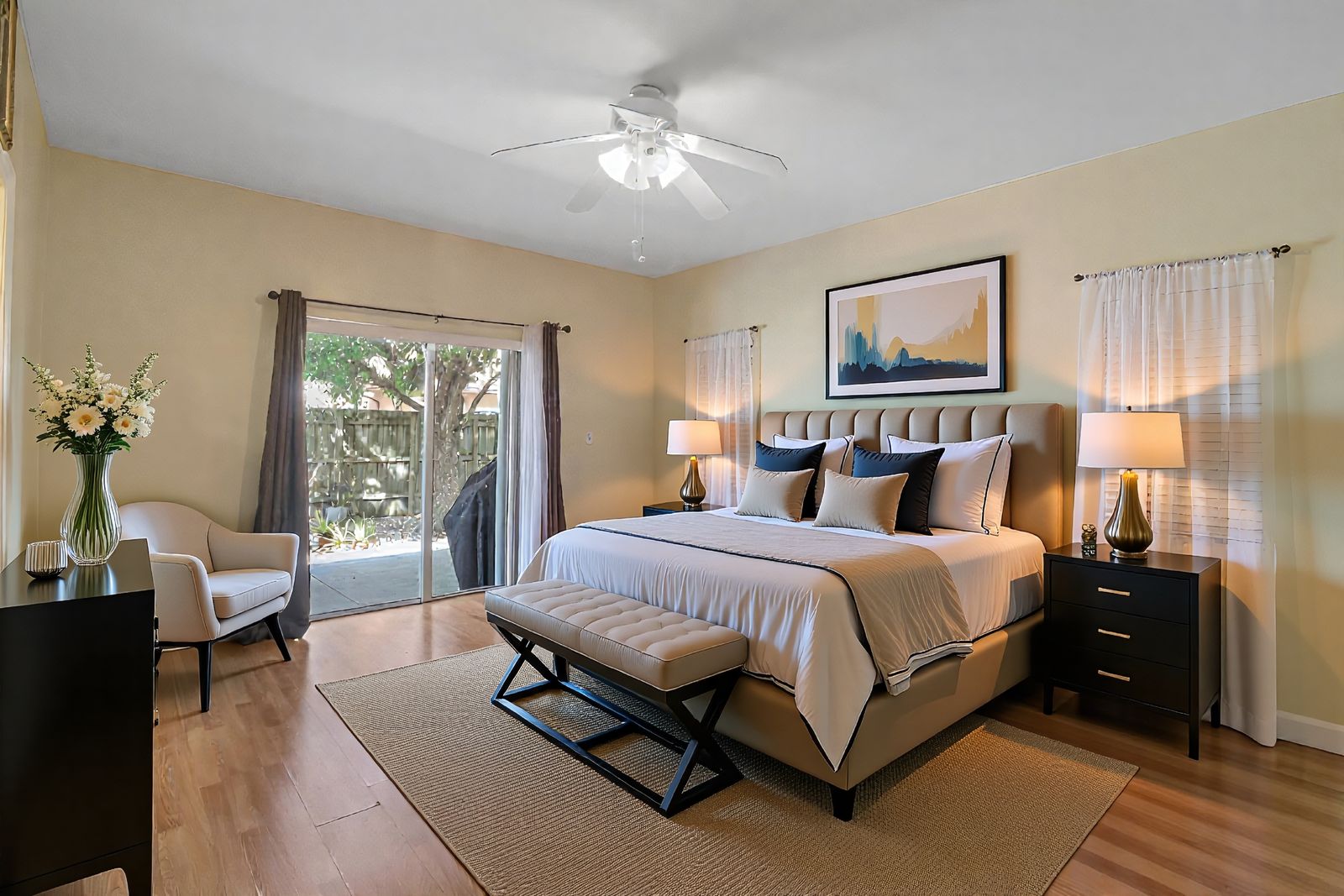 Primary bedroom with sliding doors to the backyard, virtually staged